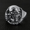 Sterling silver skull tearing through ring on a black leather background.