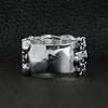 Sterling silver triple layer skulls ring back view on a black leather background.