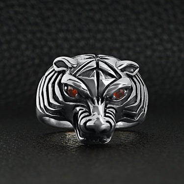 Sterling silver red Cubic Zirconia eyed tiger ring on a black leather background.