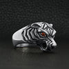 Sterling silver red Cubic Zirconia eyed tiger ring angled on a black leather background.