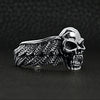 Sterling silver fanged skull with wings ring angled on a black leather background.