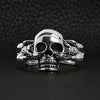 Sterling silver skull and nude women ring on a black leather background.