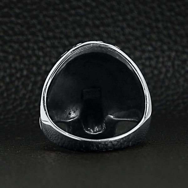 Sterling silver flaming skull ring back view on a black leather background.