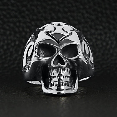 Sterling silver flaming skull ringon a black leather background.