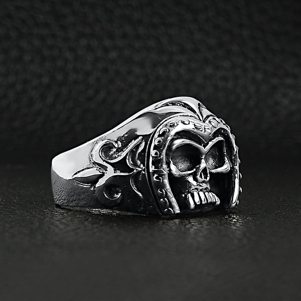 Sterling silver medieval knight warrior skull ring angled on a black leather background.