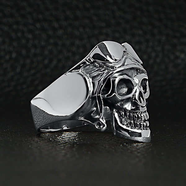 Sterling silver pilot skull ring angled on a black leather background.