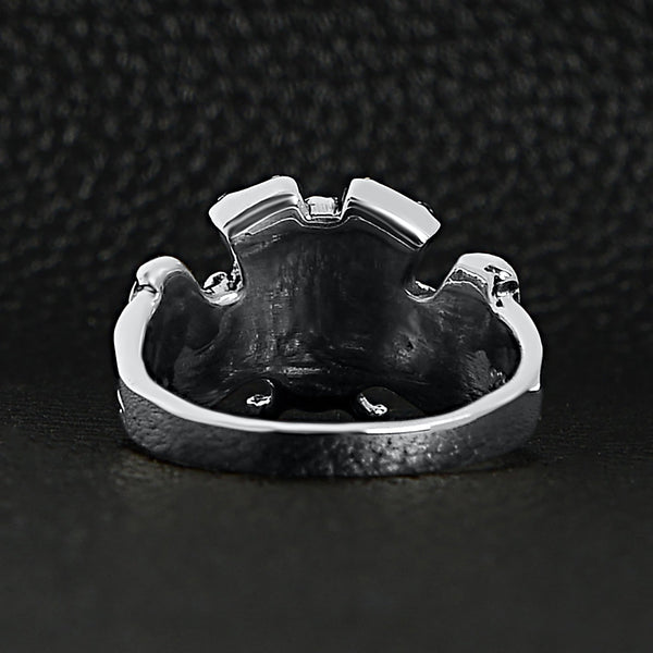 Sterling silver winged skull and crossbones eagle engine ring back view on a black leather background.