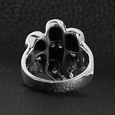 Sterling silver skull pile ring back view on a black leather background.