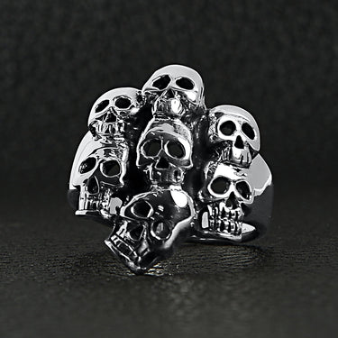 Sterling silver skull pile ring on a black leather background.