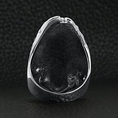 Sterling silver flaming hair skull ring back view on a black leather background.