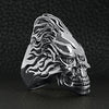 Sterling silver flaming hair skull ring at an angle on a black leather background.