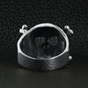 Sterling silver helmet skull and crossbones ring back view on a black leather background.