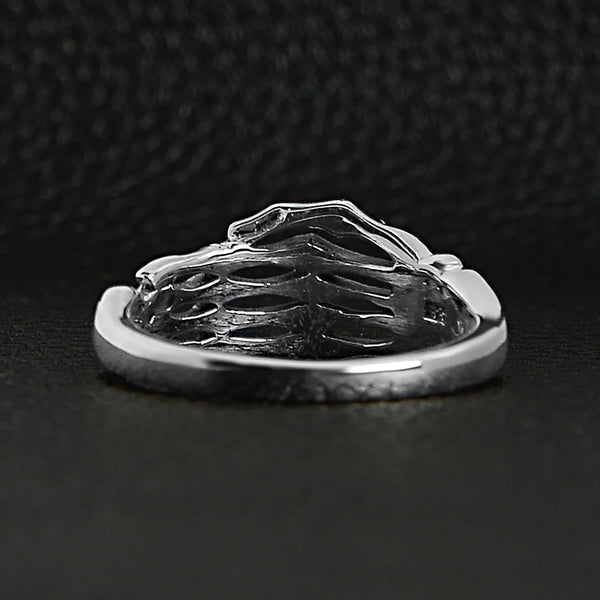 Sterling silver skeleton hand ring back view on a black leather background.