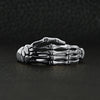 Sterling silver skeleton hand ring on a black leather background.