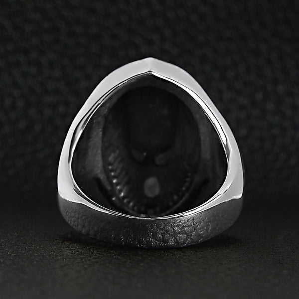 Sterling silver alien skull ring back view on a black leather background.