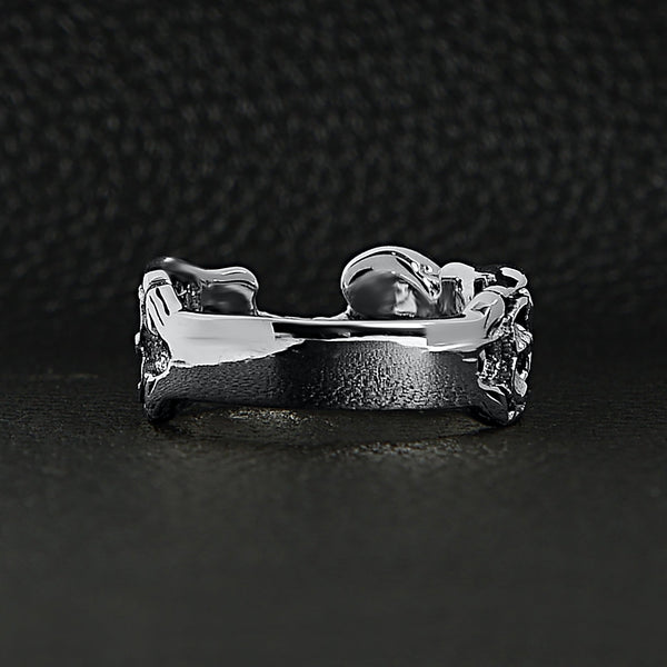 Sterling silver two skeletons ring back view on a black leather background.