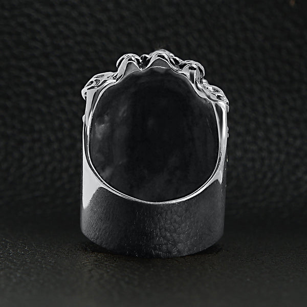 Sterling silver stacked skulls ring back view on a black leather background.