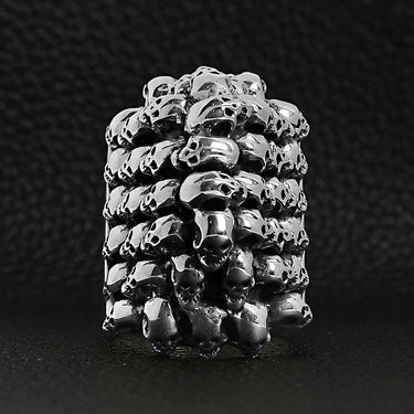 Sterling silver stacked skulls ringon a black leather background.